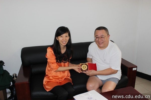 成都大学副校长、成都大学校友会副会长柯玲会见了丘小庆教授，并向其赠送了校友会纪念品.jpg