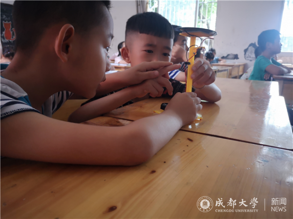 孩子们小心翼翼的完成太阳能电灯的制作，眼神里充满着期待与好奇。.png